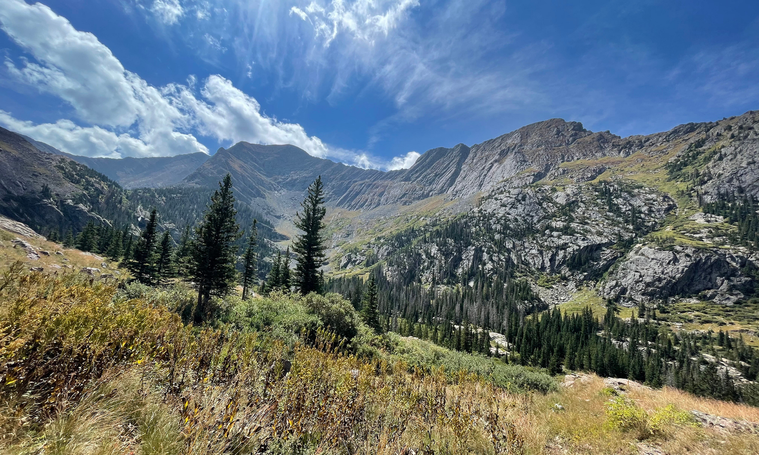 photo of a mountain range a blue skies with clouds