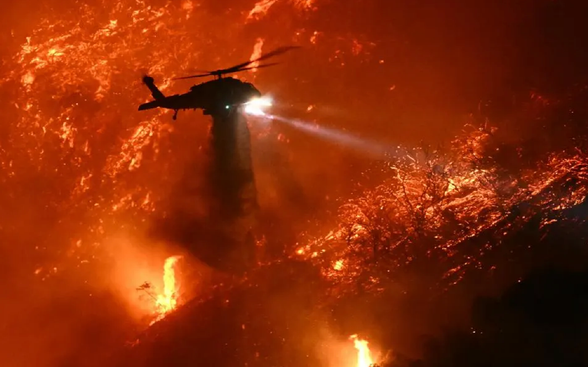 a helicopter flying over wildfire 