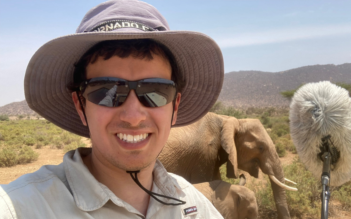 photo of Mickey Pardo wearing a hat with an elephant in the background