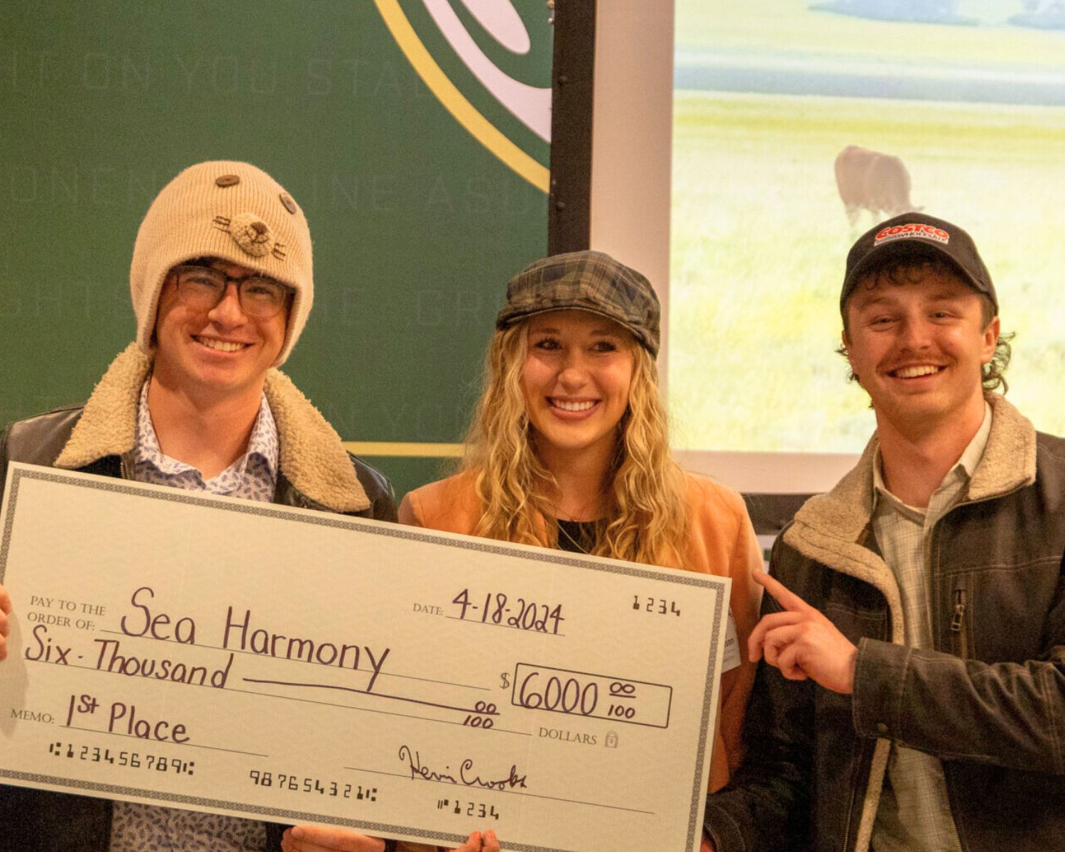 students pose with a giant check after winning first place at the Handprint Challenge