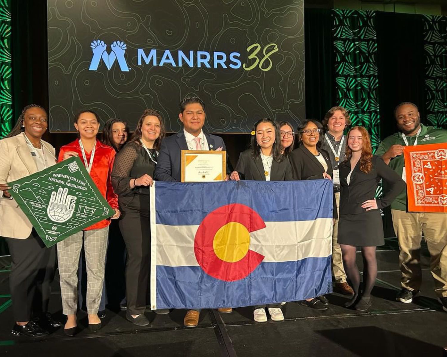 students pose with the Colorado flag at the MANRRS38 conference