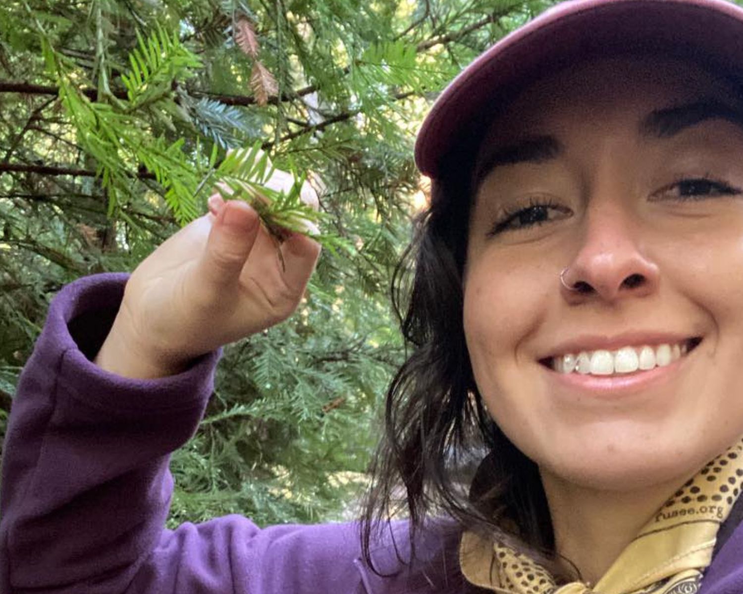 photo of Ryleigh Gelles holding a pine tree branch in her fingers