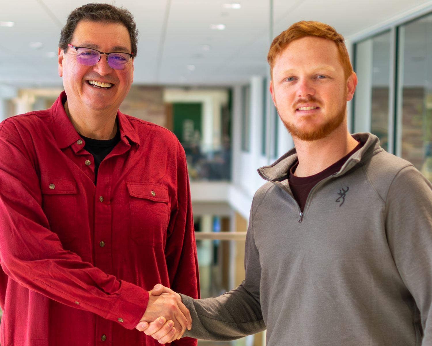 A. Alonso Aguirre and TJ Knutson shake hands