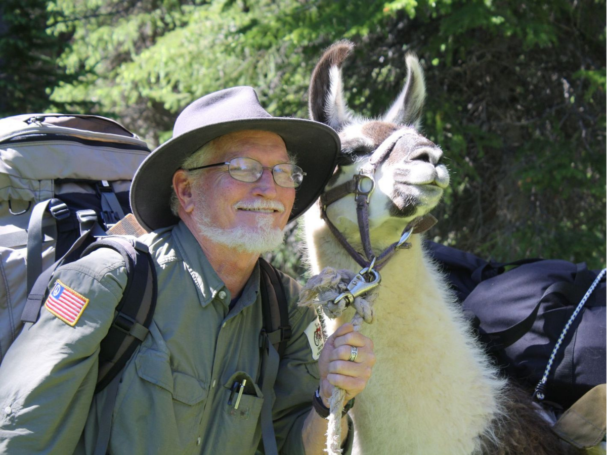 Craig MacFarland poses for a picture with a llama. 