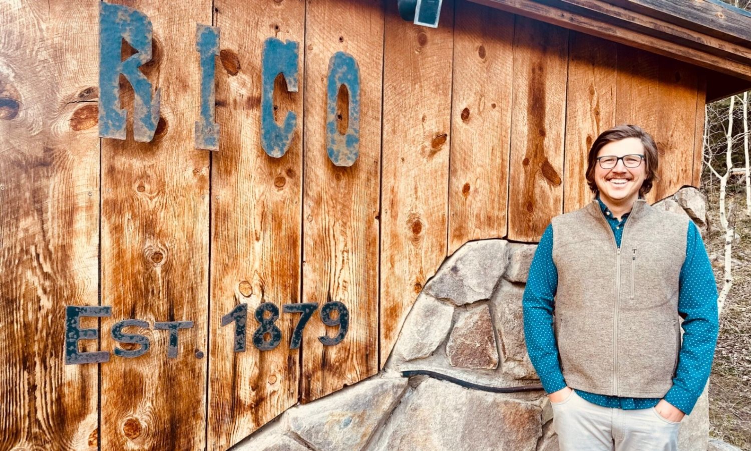 photo of Chauncy McCarthy in front of a building that says Rico Est. 1879