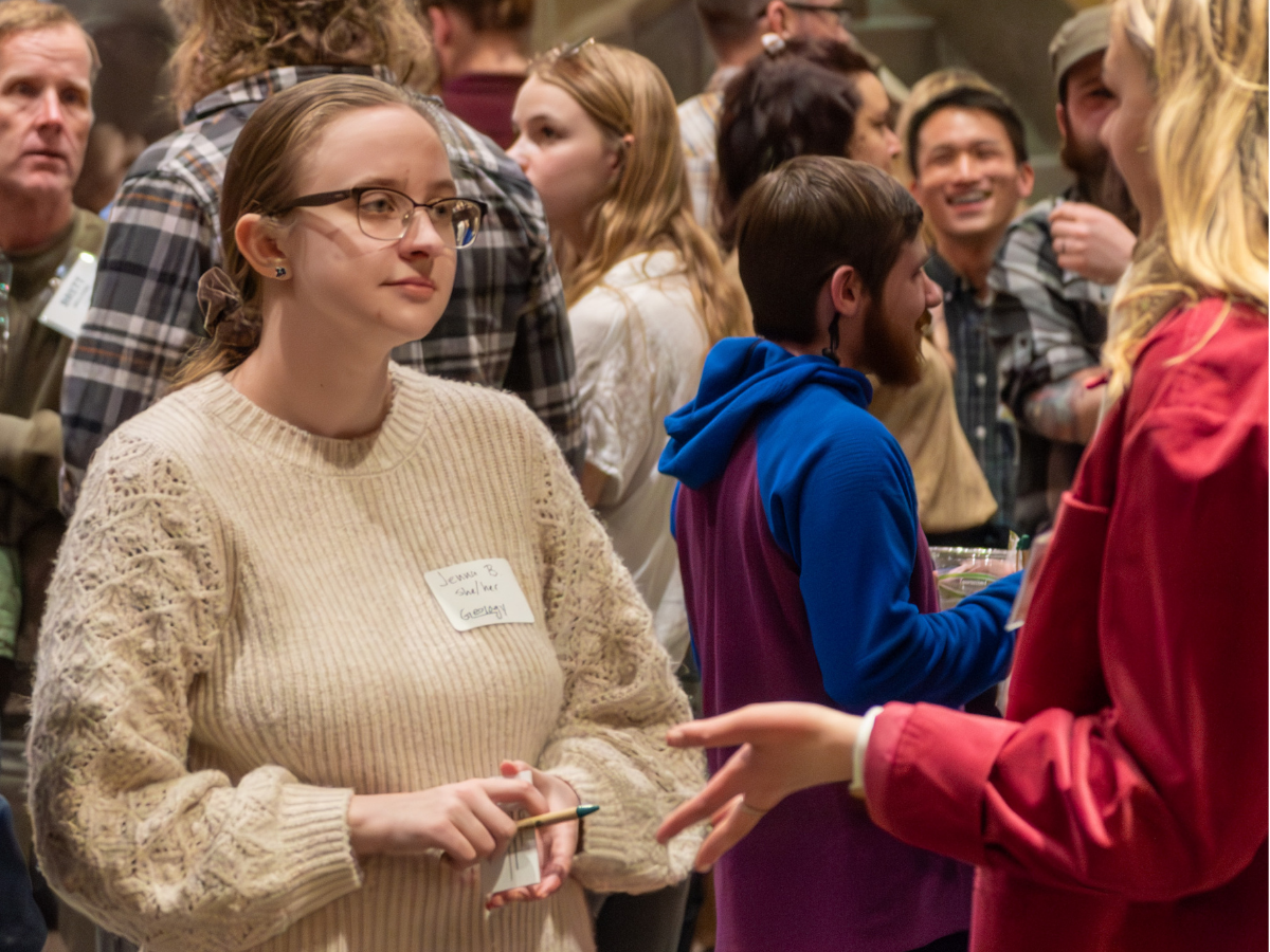A student speaks to a person at a career networking event. 