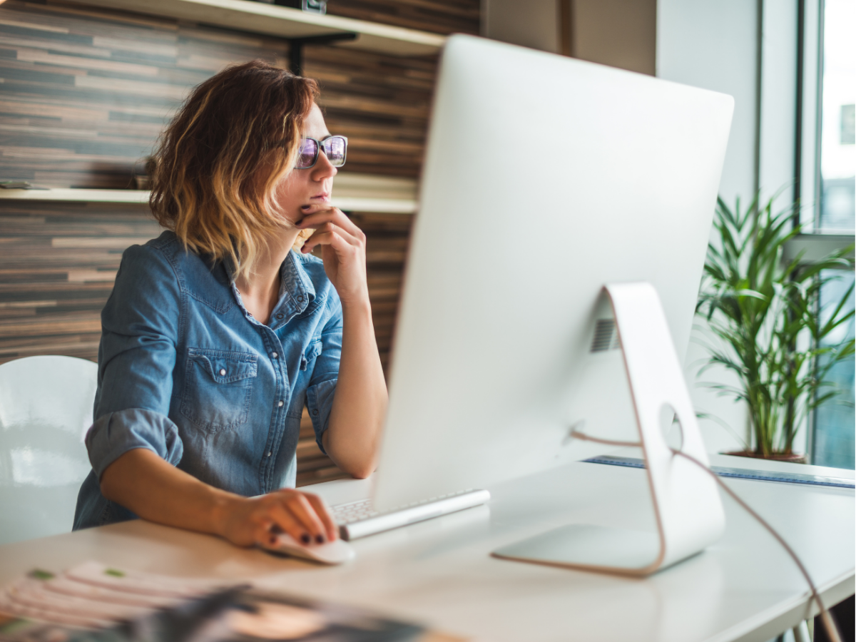 A person sits at a desk looking at a computer screen.