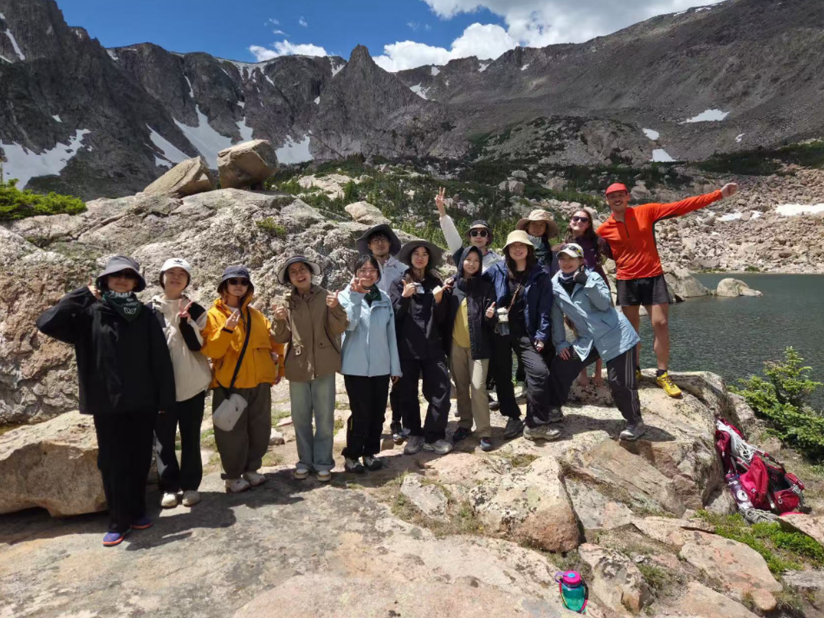Students from CCNU pose for a picture at the base of a mountain.