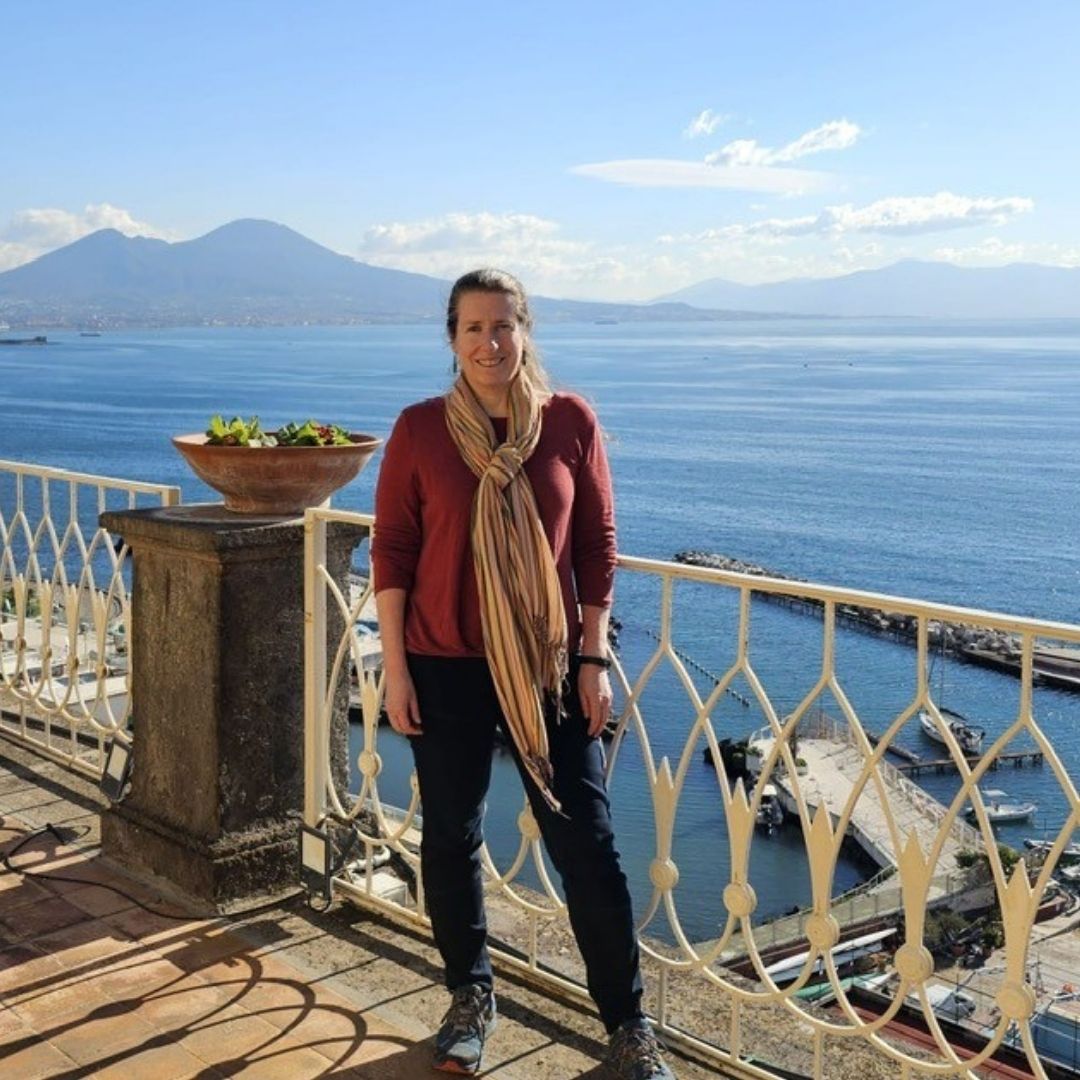 photo of Liba Pejchar standing in front of water and mountains