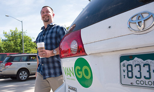 photo of a person with coffee standing near a white VanGo van