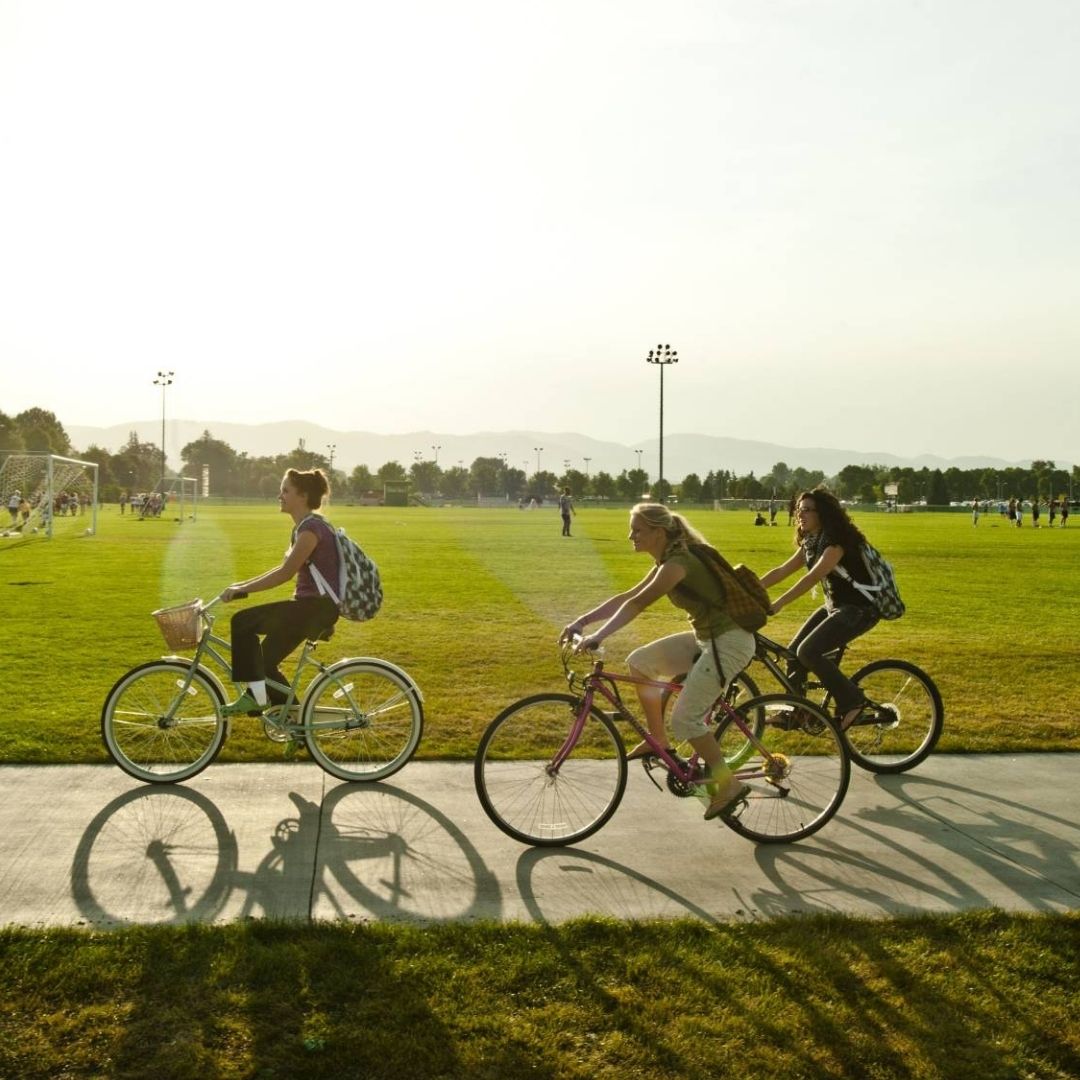 Three people ride their bikes across CSU's campus. 