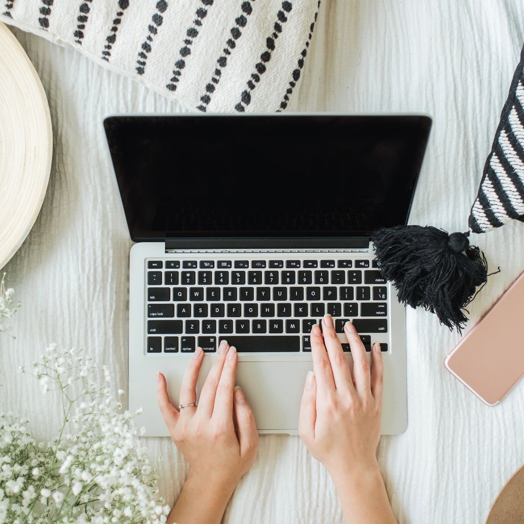 Three people hug in graduation regalia. 