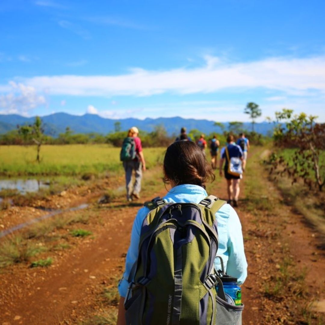 People hike along a dirt path. 