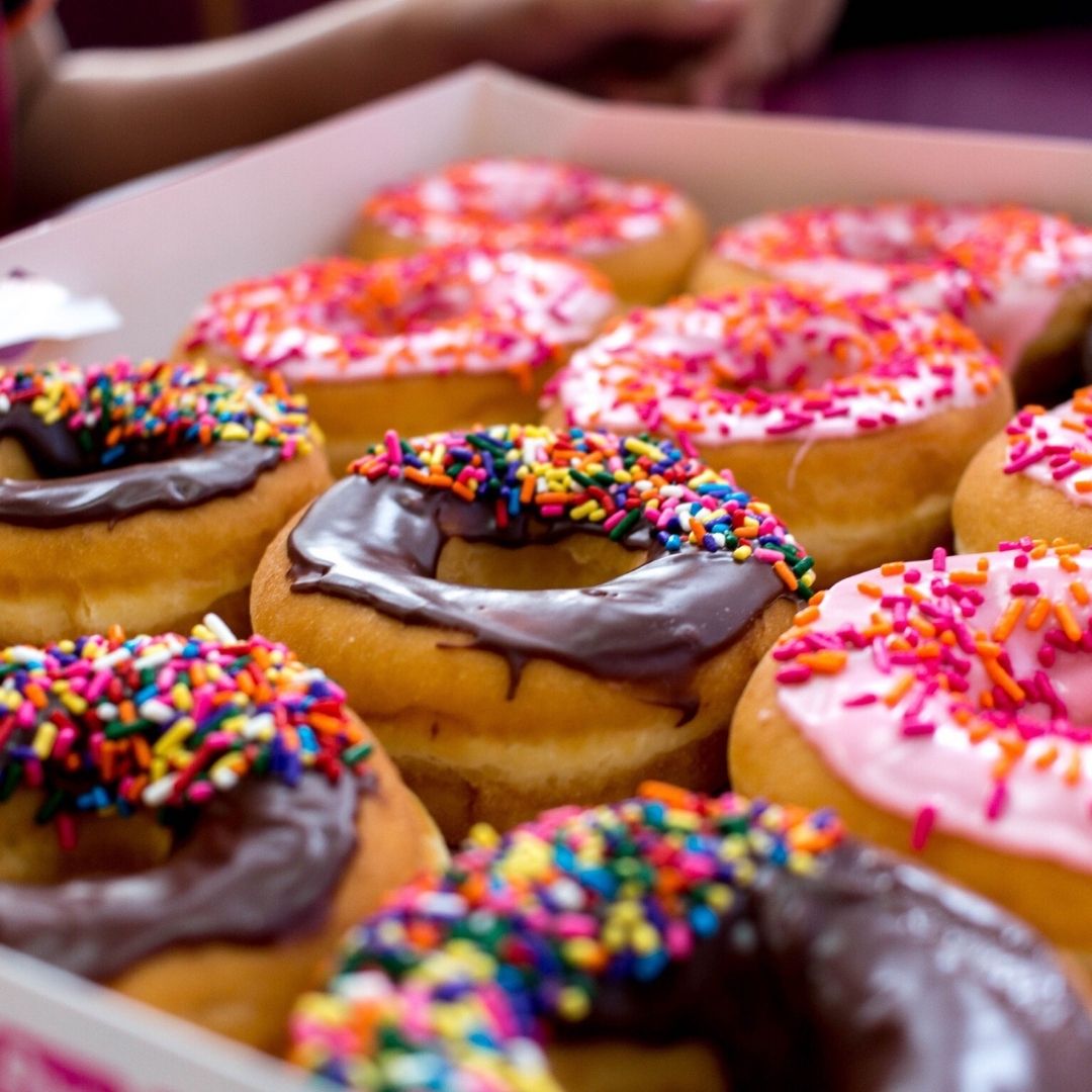 Chocolate and strawberry donuts with sprinkles. 