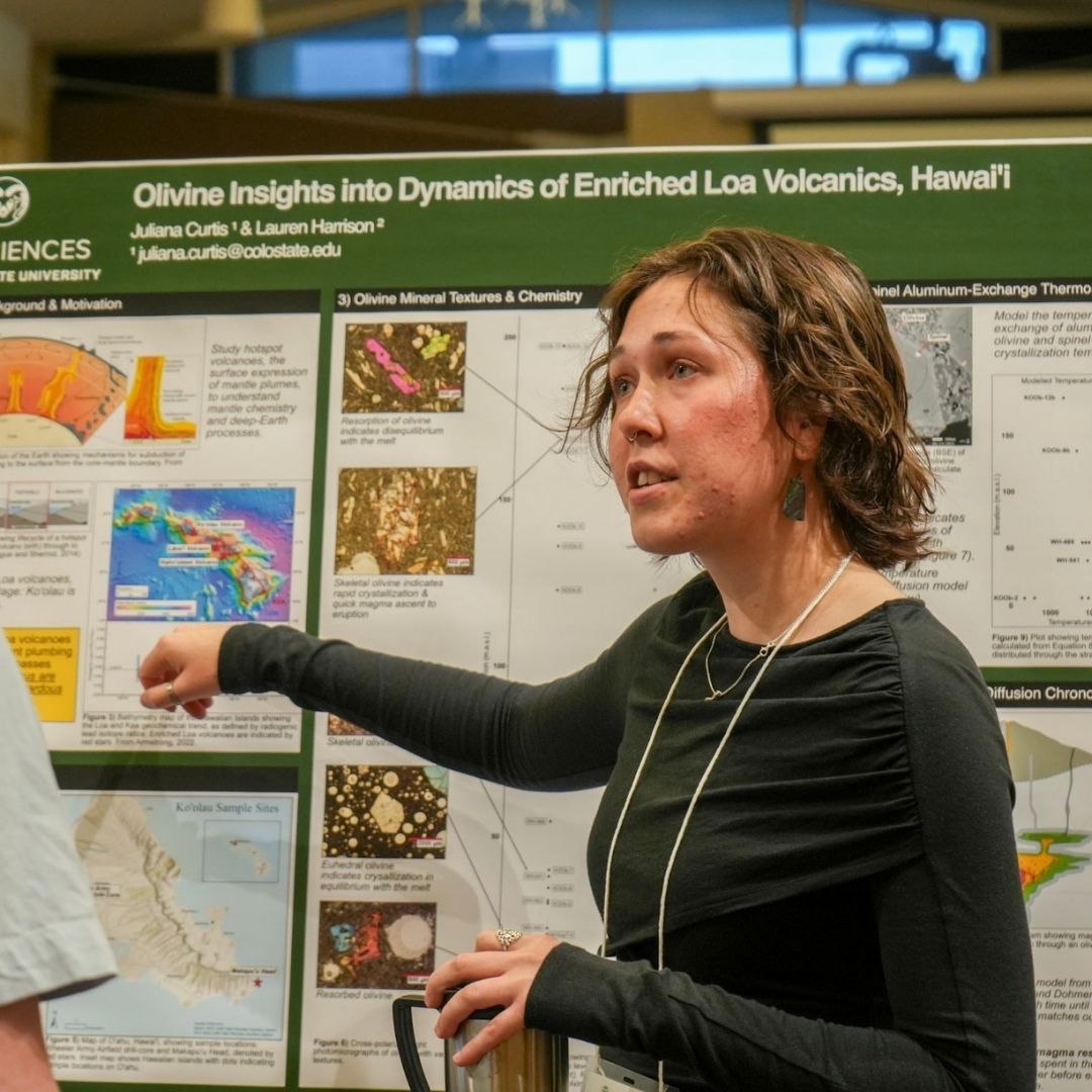 A student points to a poster board at the GradShow 2025.