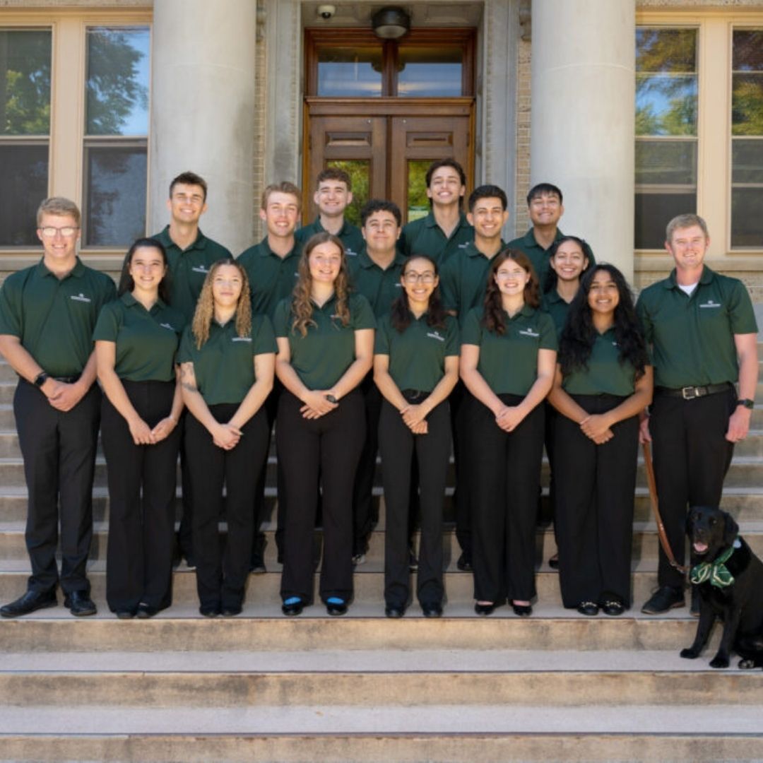 A group of Presidential Ambassadors stands on the steps of the Administration Building
