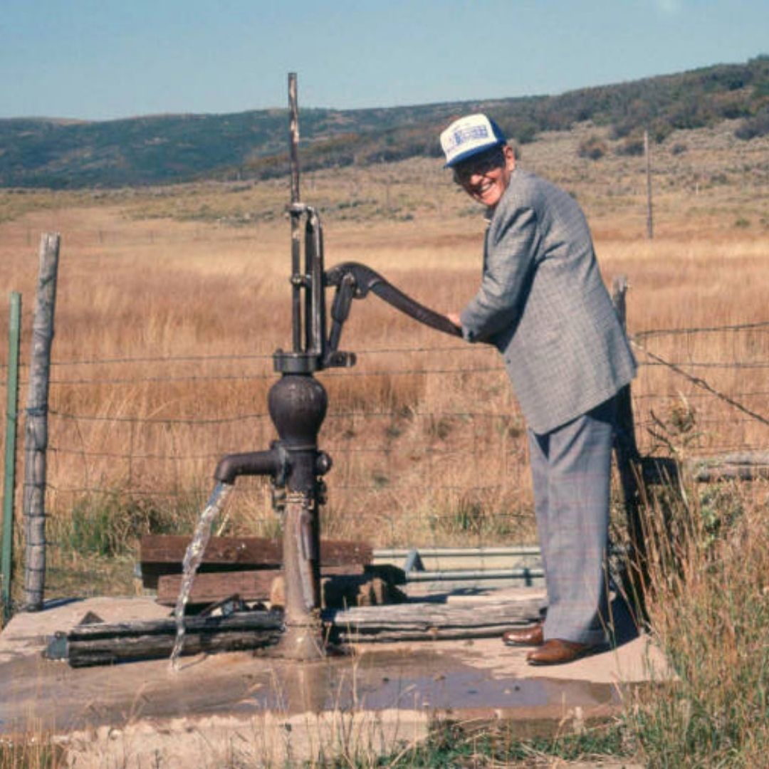 A person pumps water out of the ground. 