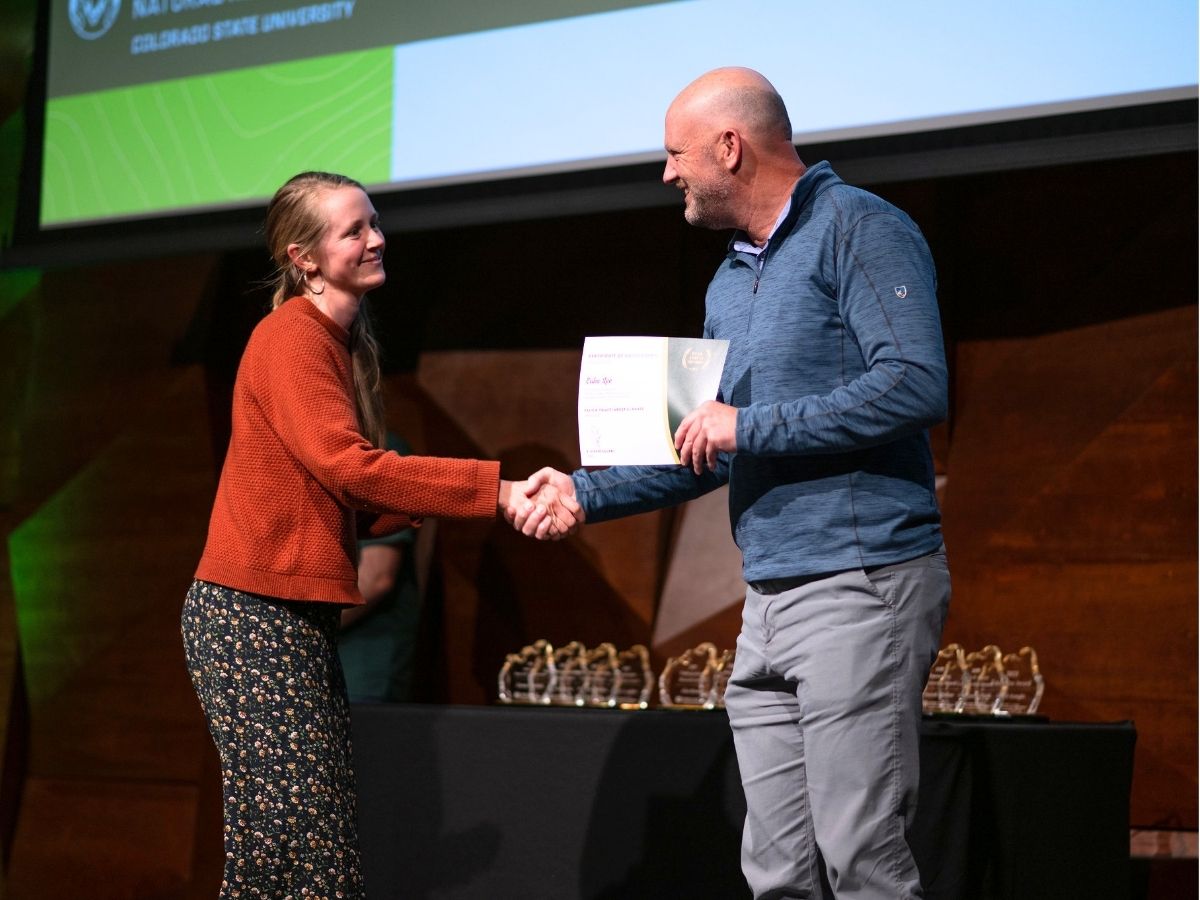 Two people shake hands at the 2025 awards reception 