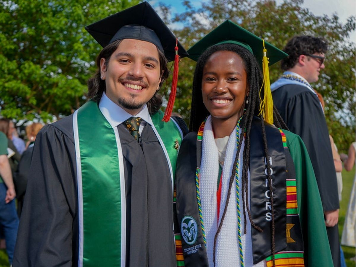 Two graduates pose for a picture.