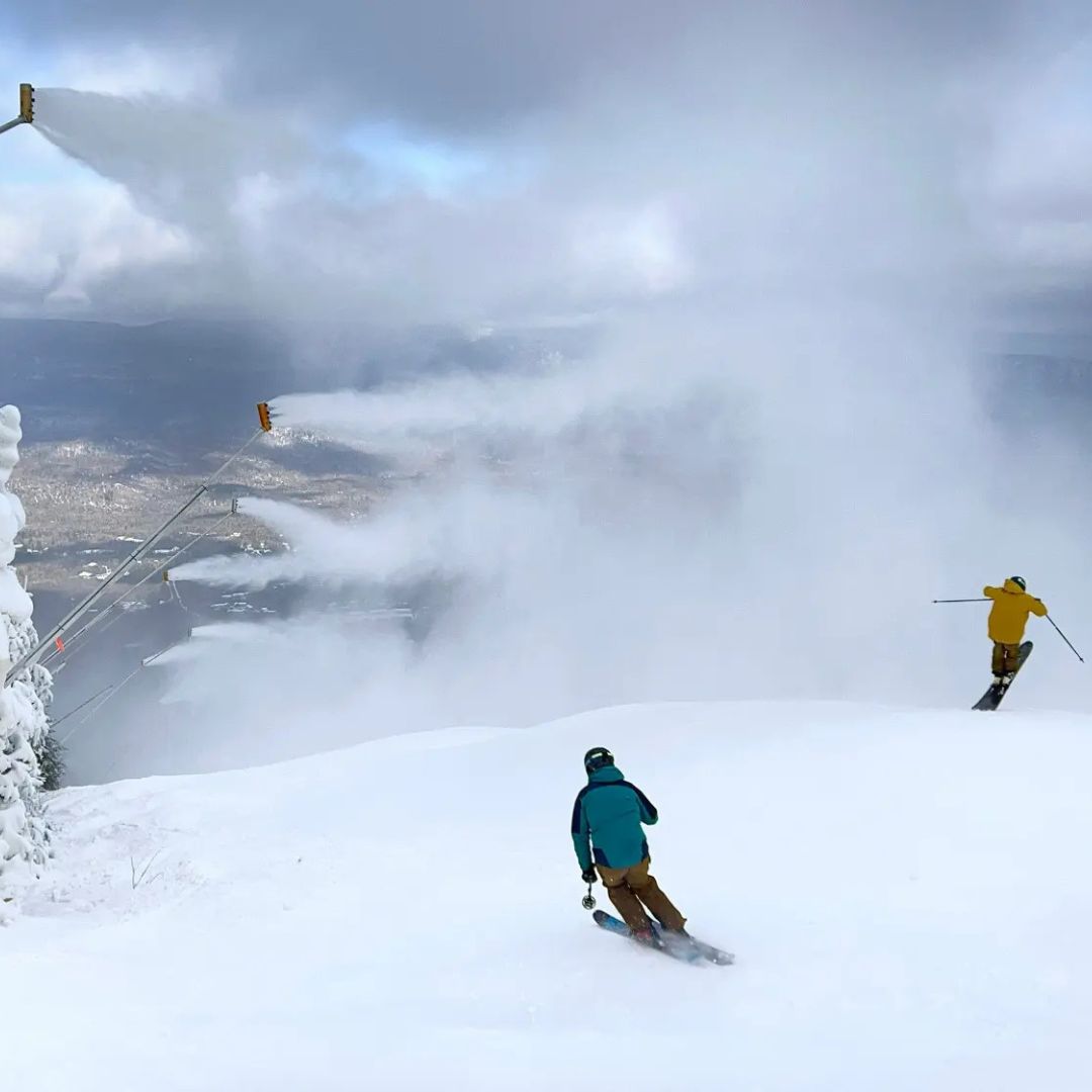 People ski on manmade snow.