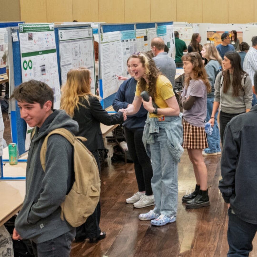 People shake hands at the 2025 CURC showcase