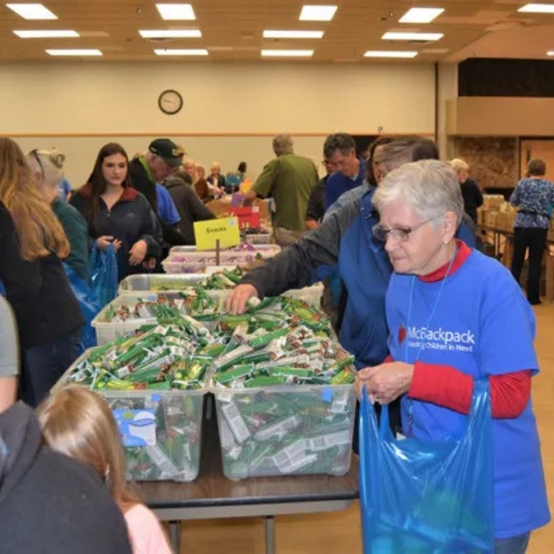 A volunteer fills bags with food. 