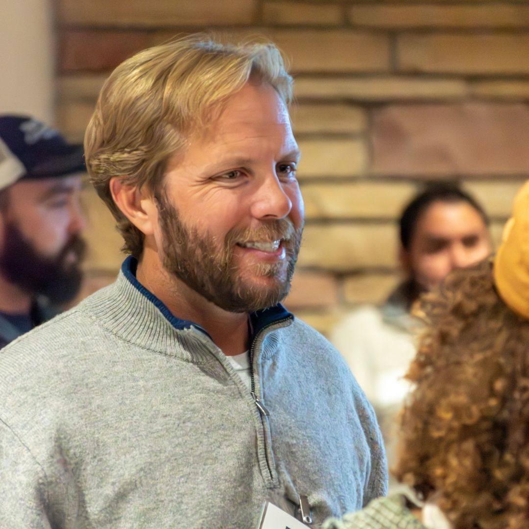 A professor talks to a student at the 2025 Networking Mixer
