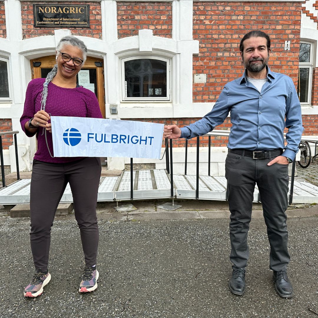 Gillian Bowser and Shai Andrè Divon hold a banner with the word Fulbright